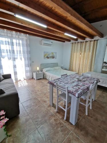 - une chambre avec une table, un lit et un canapé dans l'établissement Loft San Mauro, à Viagrande