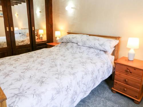 a bedroom with a bed and a dresser and a mirror at The Olde Coach House in Bradwell