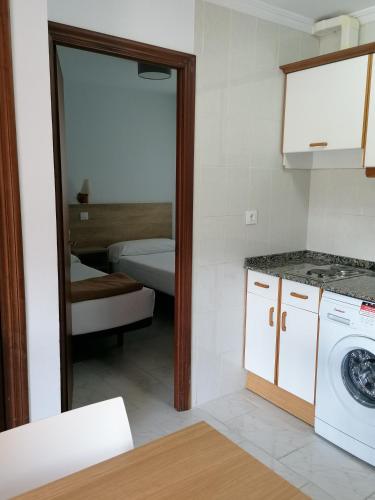 a kitchen with a washing machine and a mirror at Apartamentos Regollera in Noja