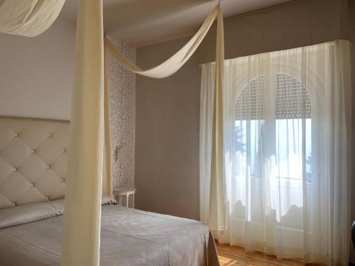 a bedroom with a bed and a large window at Hotel Bellevue in Gardone Riviera