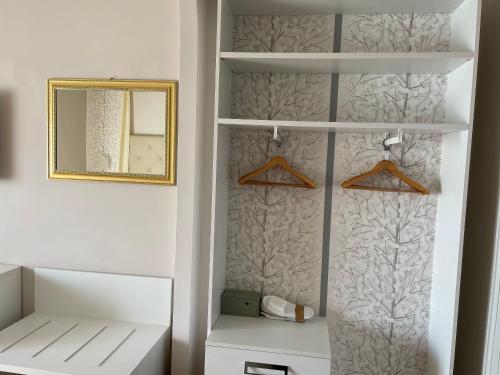a white closet with a mirror and a shelf at Hotel Bellevue in Gardone Riviera