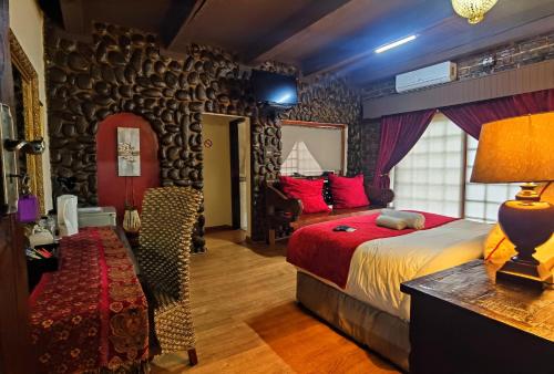 a bedroom with a bed and a table with a lamp at Camelot Guesthouse in Newcastle