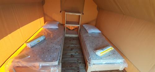 バンヌにあるTente Cabane du Camping Hautoreilleの小さな部屋 ボックス内のベッド2台付