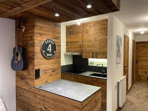 - une cuisine avec des murs en bois, un évier et une guitare dans l'établissement Tignes 2100, tout confort, à Tignes