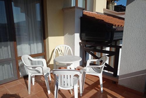 uma mesa e cadeiras numa varanda com um piano em Апартаменти плаж Червенка em Černomorec