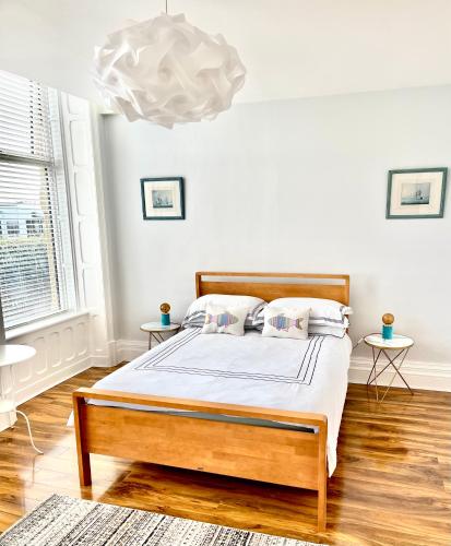 a bedroom with a bed and a chandelier at Beach Sunset in Lytham St Annes