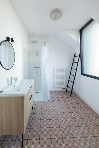 une salle de bain avec un lavabo et un miroir dans l'établissement La Canopée de Mareil, à Mareil-Marly