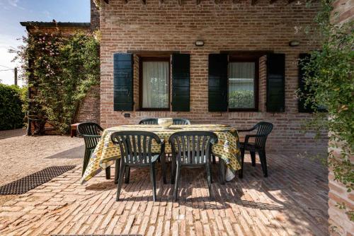 a table and chairs on a brick patio at Country house Viaro_150sqm in Vanzo
