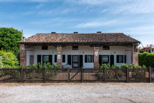 a white house with a fence in front of it at Country house Viaro_150sqm in Vanzo