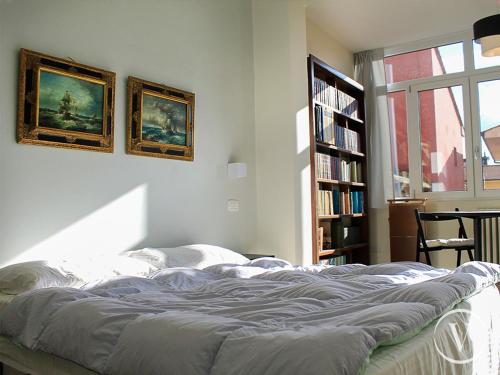 una camera con un letto e una libreria con libri di Elegante e panoramico Appartamento a Montecatini Terme