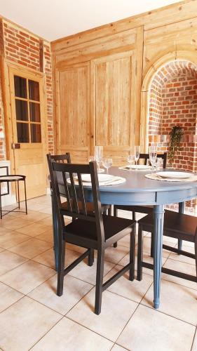 - une salle à manger avec une table, des chaises et des verres à vin dans l'établissement Le 2 pièces avec parking privé, à Honfleur