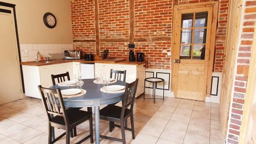 une salle à manger avec une table et des chaises dans une cuisine dans l'établissement Le 2 pièces avec parking privé, à Honfleur