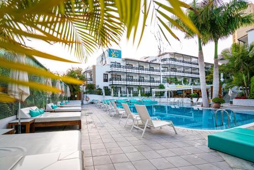 a resort with a pool and chairs and a building at Vanilla Garden Boutique Hotel - Adults Only in Playa de las Americas