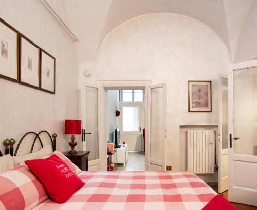 1 dormitorio con cama a cuadros roja y blanca en Sweet Home Pitti, en Crema