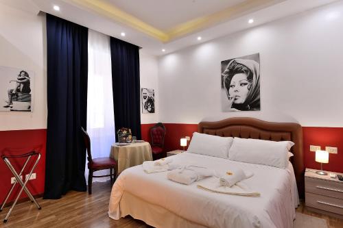 a bedroom with a bed and a table with a chair at DolceVeneto Rooms & Suites in Rome
