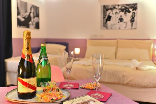 eine Flasche Champagner und zwei Gläser auf dem Tisch in der Unterkunft DolceVeneto Rooms & Suites in Rom