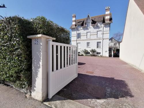 een witte poort voor een wit huis bij A la "Georgette" et son jardin avec parking in Villers-sur-Mer