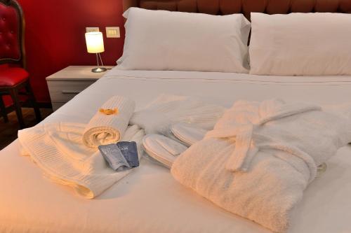 ein Bett mit Handtüchern und einem Bademantel darauf in der Unterkunft DolceVeneto Rooms & Suites in Rom