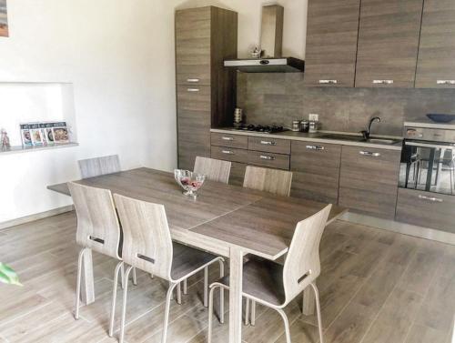 a kitchen with a wooden dining table and chairs at La Casa all'Oliveto in Pitigliano