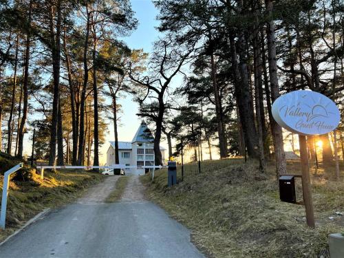 a house on the side of a road with a sign at Vallery Guest House in Bigauņciems