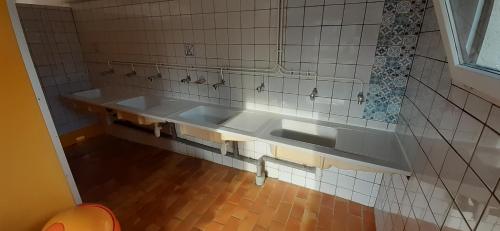 a bathroom with a sink and a tiled wall at Tente Cabane du Camping Hautoreille in Bannes