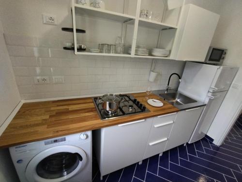 a kitchen with a washing machine and a counter top at Casa Vacanze Playa 54 in Castellammare del Golfo
