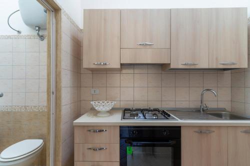 uma pequena cozinha com um lavatório e um fogão em Soleado Apartments by BarbarHouse em Porto Cesareo
