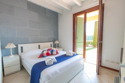 una camera da letto con un letto e asciugamani di Lugana Resort & Sporting Club - Bassana Village a Peschiera del Garda