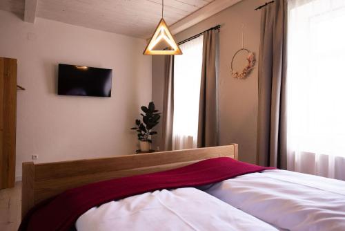 a bedroom with a bed with a red blanket on it at Monschein Weingut Straden in Straden