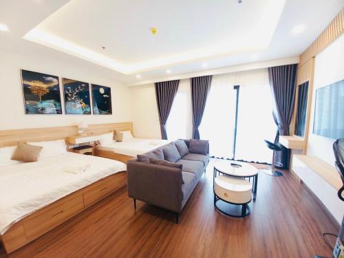 a hotel room with a bed and a couch and a table at FLC SEA TOWER - Quy Nhơn in Quy Nhon