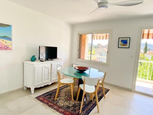 a dining room with a table and chairs and a tv at Appartement avec terrasse à 100m de la plage in Saint-Cyr-sur-Mer