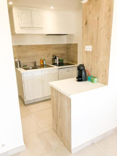 une cuisine avec des armoires blanches et un comptoir dans l'établissement Appartement la Frégate avec terrasse à 100m de la plage, à Saint-Cyr-sur-Mer