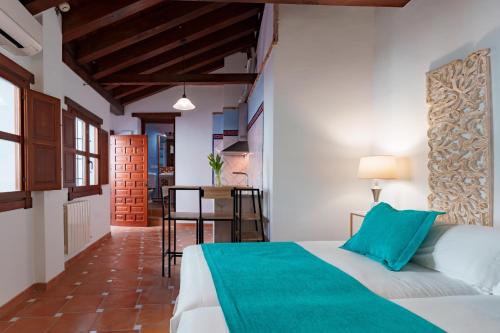 a bedroom with a bed and a table in a room at SUITES CASA DE LAS COLUMNAS in Granada