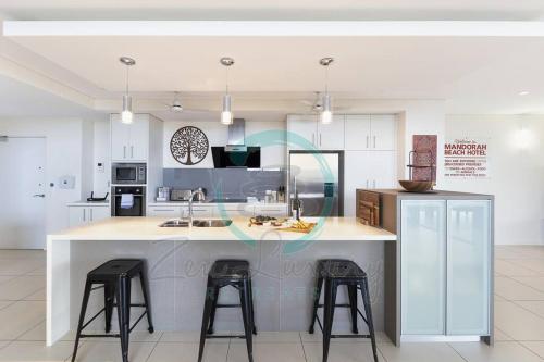 a kitchen with a large island with two bar stools at ZEN LUXURY: 2-Story 4-BR Penthouse in Darwin City with Mindal Markets & Harbour Views in Darwin