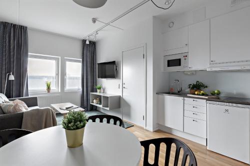 a kitchen and living room with a table and chairs at Forenom Hotels & Apartments Kista in Stockholm
