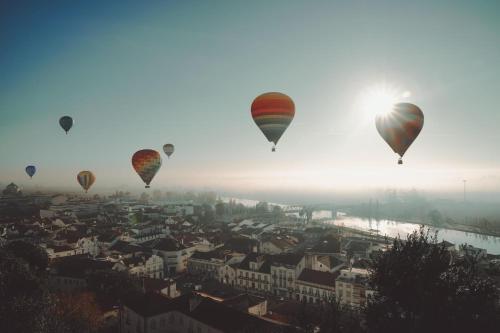 a group of hot air balloons flying over a city at Pátio da Villa - Coruche Boutique Guest House in Coruche