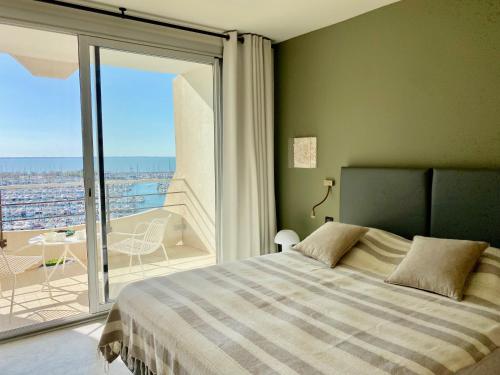 une chambre avec un lit et un balcon avec vue dans l'établissement LA SUITE - La Grande Motte P2 Avec Vue Panoramique, clim, WIFI, à La Grande Motte