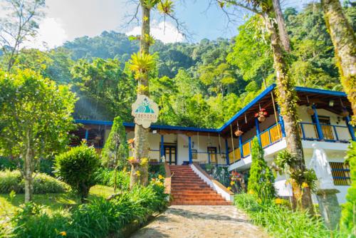a house in the middle of a forest with trees at FINCA HOTEL CARMONIA DEL BOSQUE in Venecia