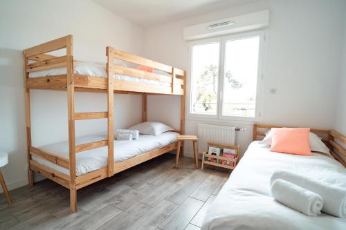 ラ・テスト・ド・ビュシュにあるSEAHORSE - Spacieux Appartement proche du port de la Testeのベッドルーム1室(二段ベッド2台、窓付)が備わります。
