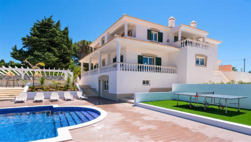 a villa with a swimming pool in front of a house at Vida Boa Lodge in Lagos