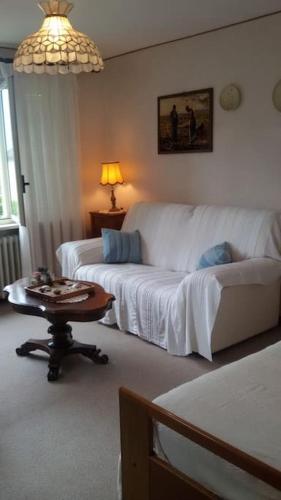a living room with a white couch and a table at Le Jasmin da Marina in Saint Vincent