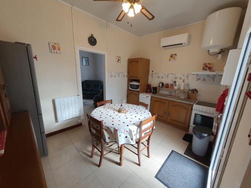 une cuisine avec une table et des chaises dans une pièce dans l'établissement maison Jacques jean classée 4 etoiles, à Mimizan