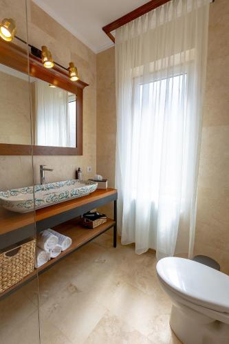a bathroom with a sink and a toilet and a mirror at San Gennaro in Sighişoara