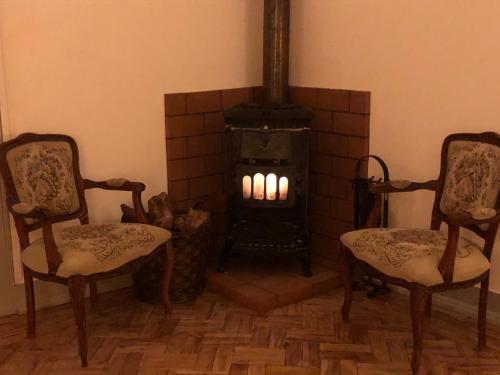 a living room with two chairs and a fireplace at Pátio da Villa - Coruche Boutique Guest House in Coruche