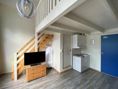 a living room with a tv and a staircase at Hotel Svartisen in Mo i Rana