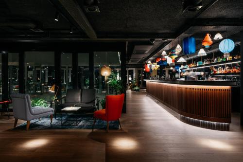 a restaurant with a bar with a view of the city at Ruby Claire Hotel Geneva in Geneva