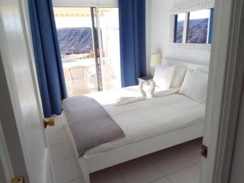 プラヤ・デル・クーラにあるMonseñor Ocean View Apartmentのベッドルーム1室(青いカーテン、窓付)