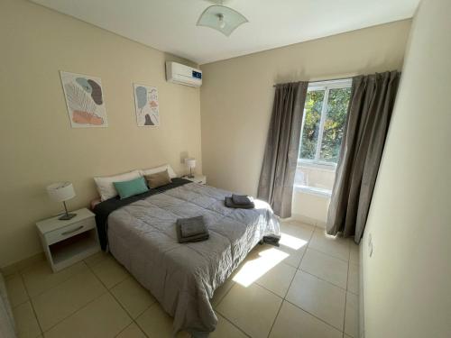 a bedroom with a large bed and a window at Moderno Departamento con cochera in Mendoza