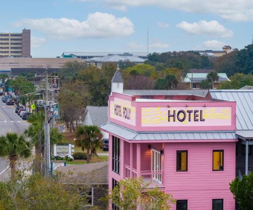 een roze gebouw met een hotelbord erop bij Hotel Folly with Marsh and Sunset Views in Folly Beach