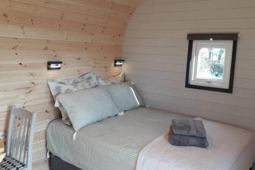 a small room with a bed and a window at Hornbeam Luxury Eco Pod at Trewithen Farm Glamping in Launceston